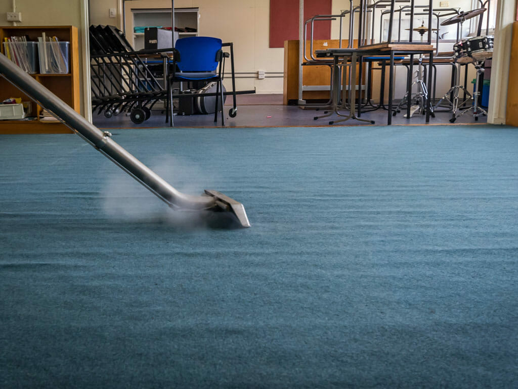 Vacuum cleaning a carpet in a school